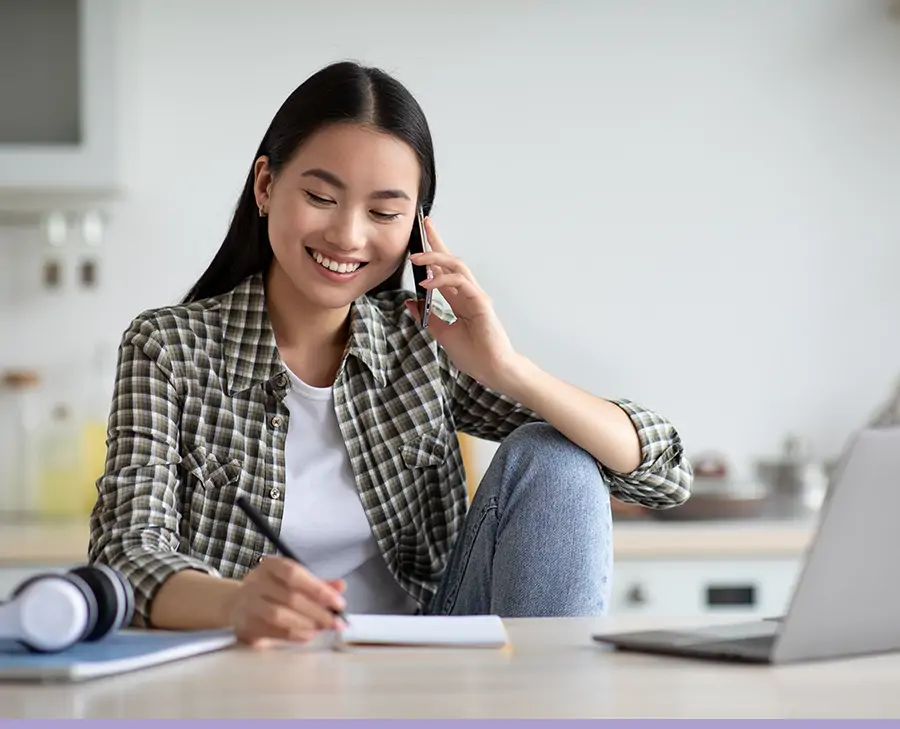 A homeowner on the phone taking notes, staying calm and in contact with their lender