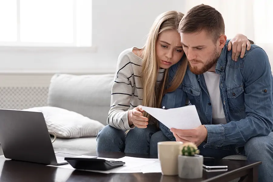 A homeowner reviewing paperwork with a concerned expression